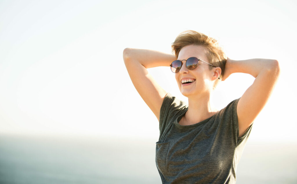 Woman wearing glasses in a relaxed state in front of the ocean